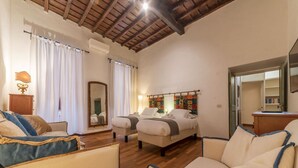 Une pièce spacieuse avec deux lits, un plafond en bois et un grand miroir.