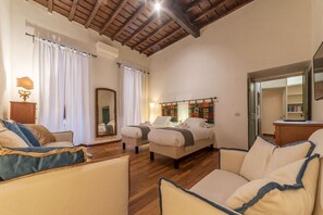 A spacious room with two beds, a wooden ceiling, and a large mirror. - Unique opportunity to live in a Renaissance palace (Roma)