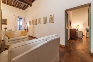 A spacious living area with a sofa, a dining table, and a lamp. - Unique opportunity to live in a Renaissance palace (Roma)