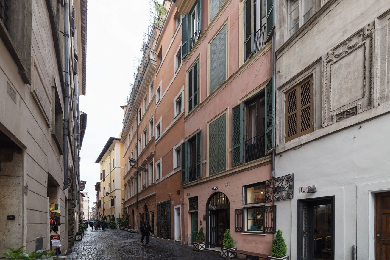 Eine enge Kopfsteinpflasterstraße gesäumt von historischen Gebäuden mit Balkonen und traditionellen Fensterläden.