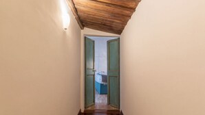 A narrow hallway with wooden flooring and a sloped ceiling. - Unique opportunity to live in a Renaissance palace (Roma)