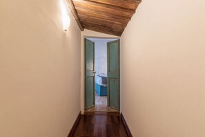A narrow hallway with wooden flooring and a sloped ceiling. - Unique opportunity to live in a Renaissance palace (Roma)