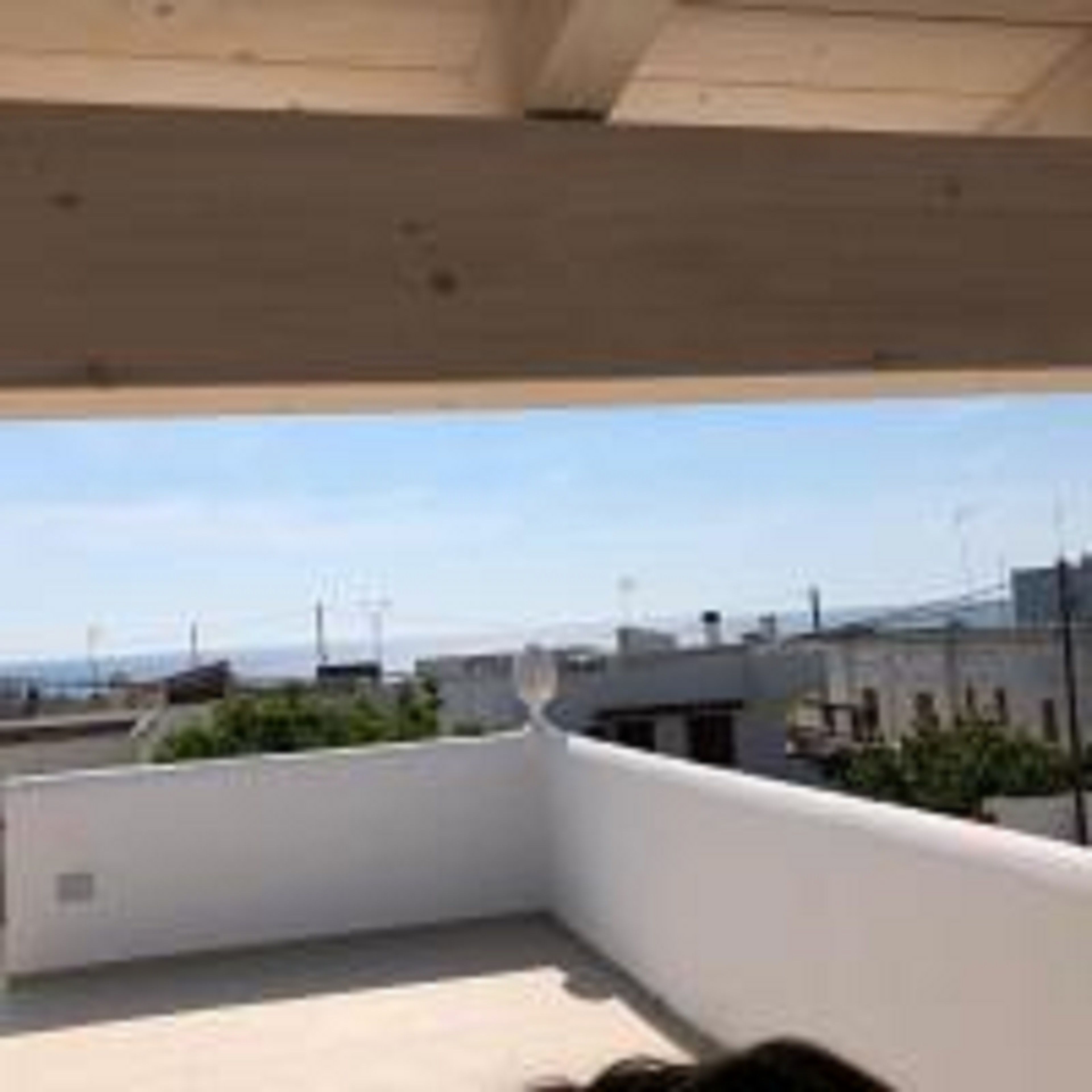 Une terrasse sur le toit offrant une vue dégagée sur le paysage urbain, avec les bâtiments et l’horizon au loin.