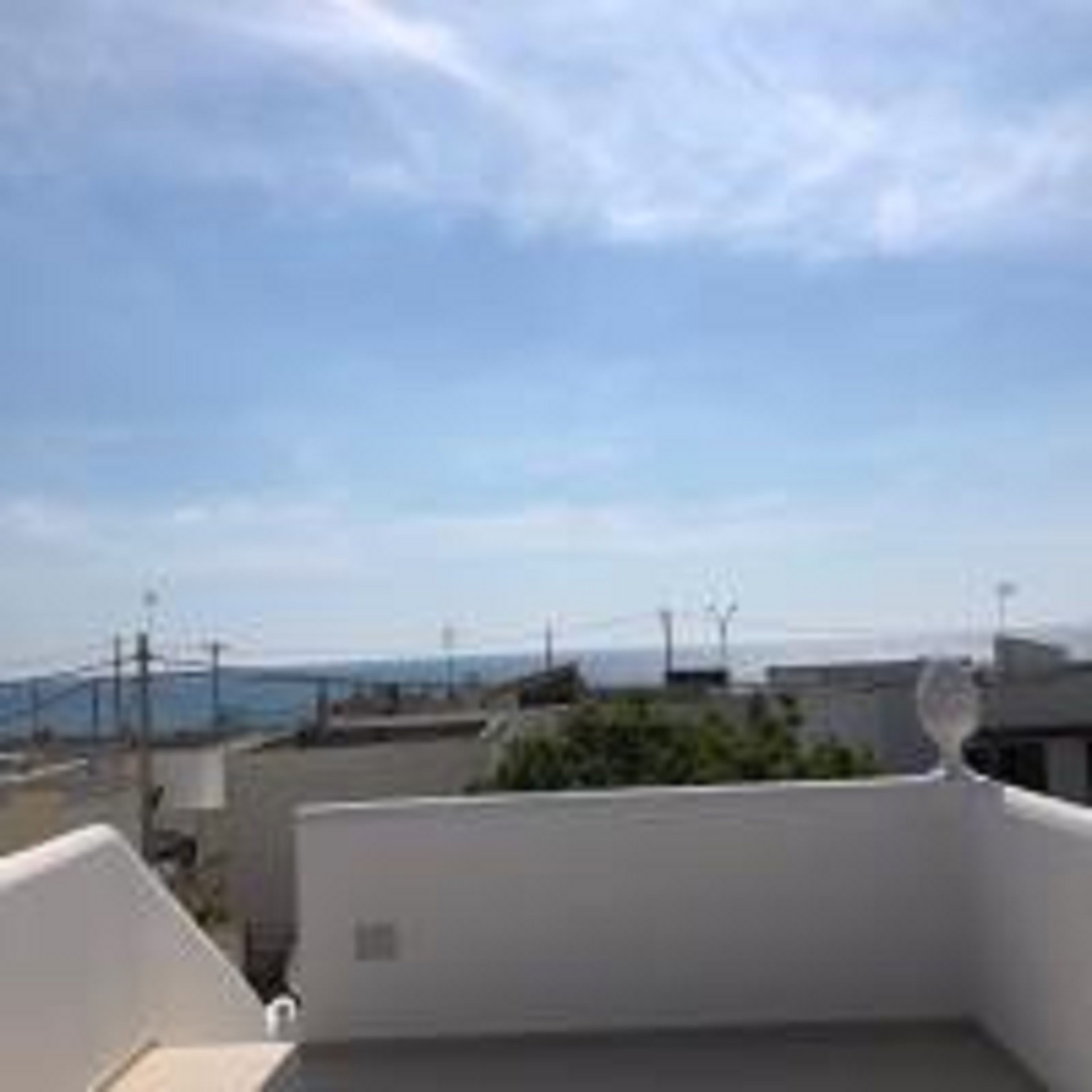 Una terraza en la azotea con vistas despejadas al mar y edificios lejanos.