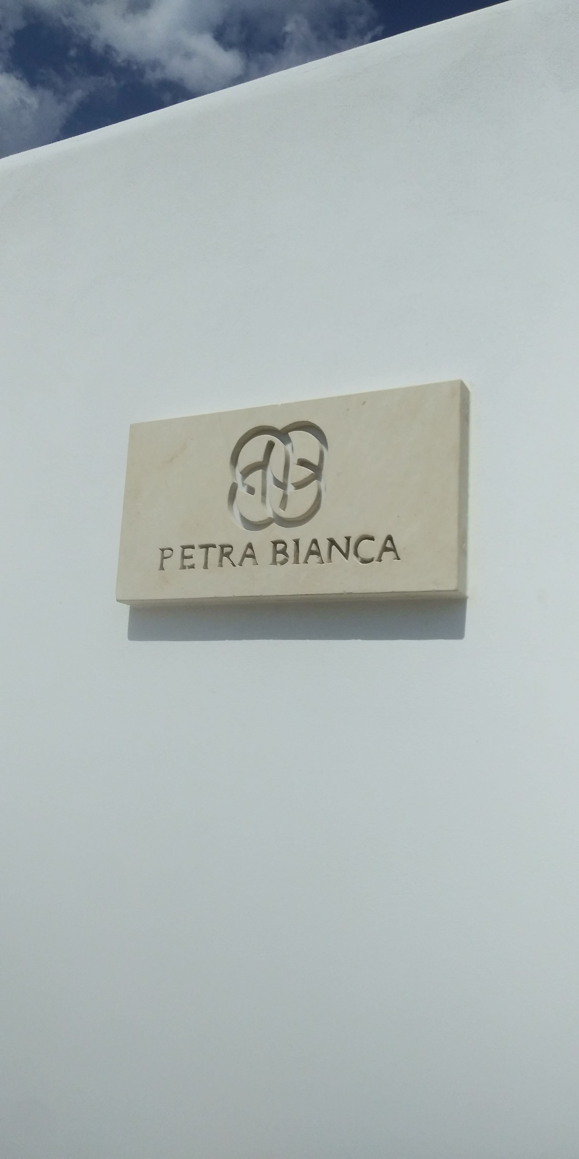 Ein Schild mit dem Text „PETRA BIANCA“ und einem Logo.
