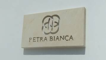 Un letrero con el texto 'PETRA BIANCA' y un logotipo.