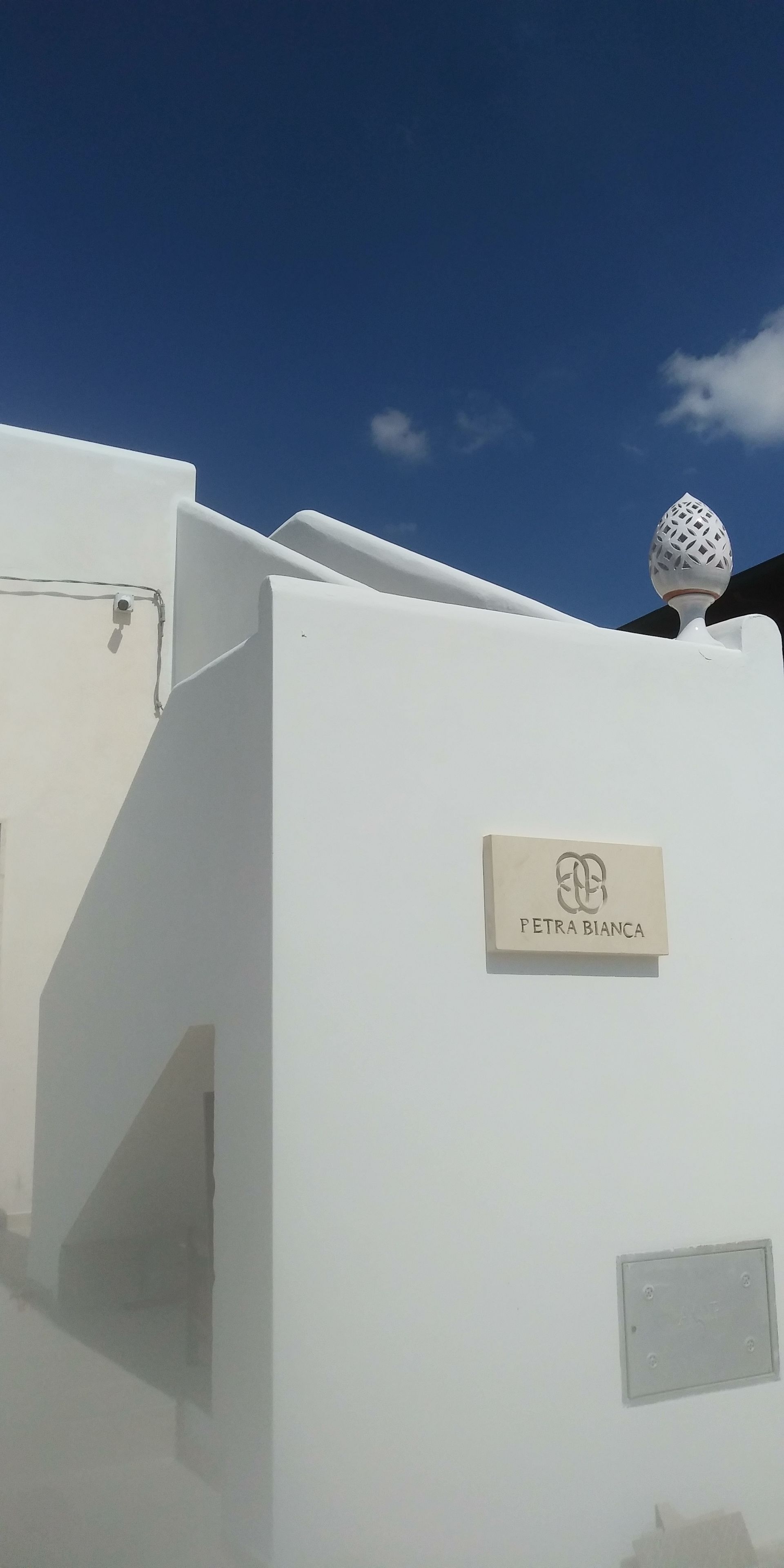 A building with a white exterior and a sign that reads "PETRA BIANCA".