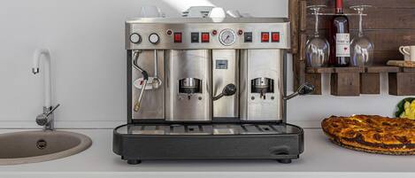 Macchina da caffè espresso professionale con erogatore d'acqua, lancia vapore e numerosi pulsanti di controllo.