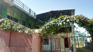 A gated entrance with a metal gate and a concrete wall. - Elation Guest House & Musafir Cafe (Ranikhet)
