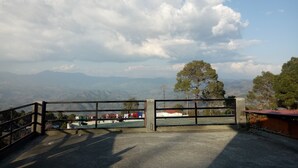 A gated entrance with a view of distant mountains and a clear sky. - Elation Guest House & Musafir Cafe (Ranikhet)