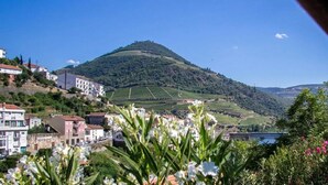 Une ville située sur une colline, avec des bâtiments, un pont et une montagne en arrière-plan.