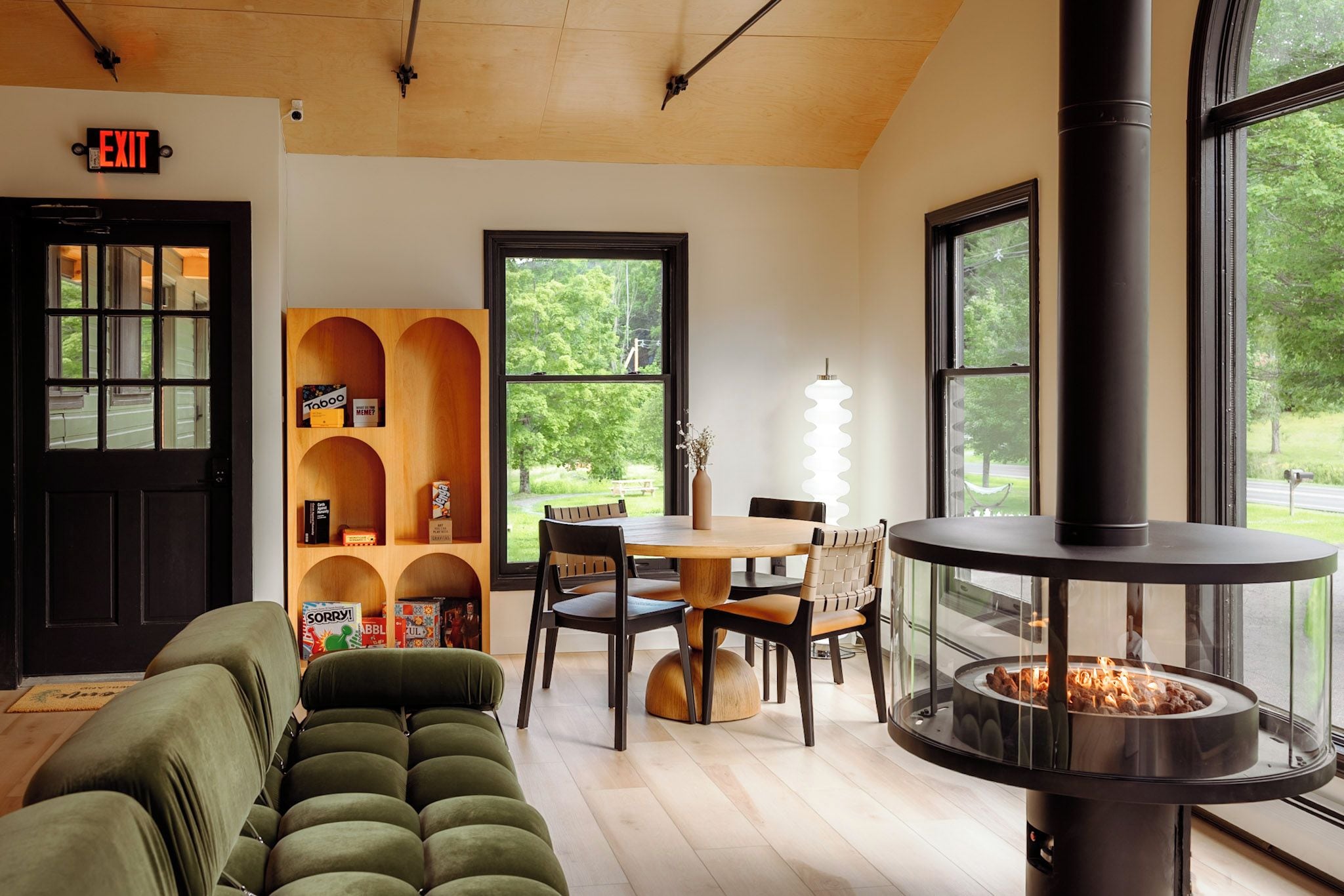 Un interior acogedor con chimenea, un sofá, una mesa de comedor y una estantería.