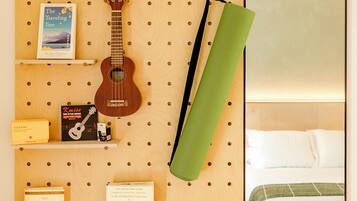 A wall-mounted pegboard with books, a ukulele, and a green towel.