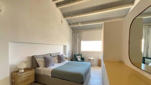 A modern bedroom with a large bed, bedside table, and a mirror. - Ortigia Luxury Apartment w/ Sea View & Terraces (Syracuse)