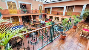 A multi-level atrium with a glass ceiling, potted plants, and a fountain.