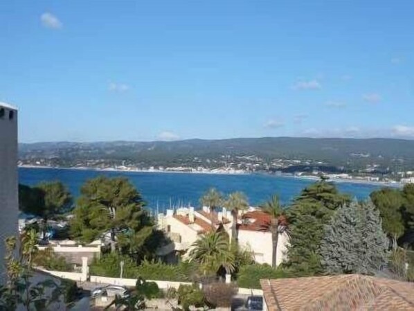 A coastal view with a clear sky, a beach, and residential buildings.