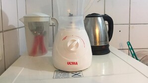 Un taulell de cuina amb un batlle, una papereta i un gerro de vidre.