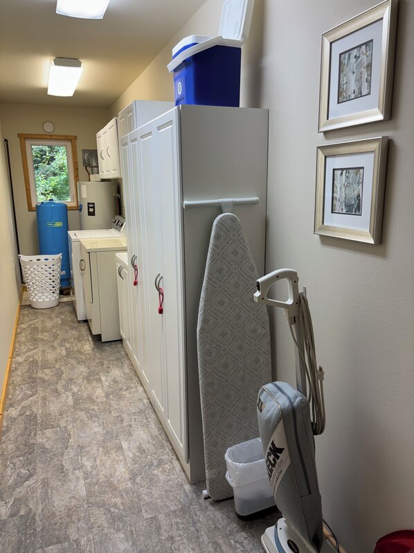 A compact kitchen with a refrigerator, a washing machine, and a sink.