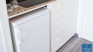 Een kleine keuken met een ingebouwde kookplaat, een spoelbak en een magnetron.