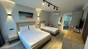 A modern hotel room with two beds, a small desk, a chair, and a mirror. - Duman Boutique Hotel (Cesme)