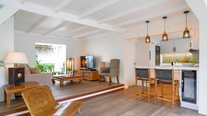 Un espace de vie et de salle à manger moderne, à aire ouverte, avec une cuisine, un plancher en bois et des luminaires suspendus.