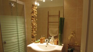 Ein Badezimmer mit Waschbecken, Spiegel und Pflegeprodukten.