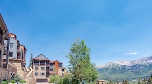 A multi-story building with balconies, a mountain view, and a clear sky. - Cassidy Ridge C-402 Mountain Village Condo (Mountain Village)