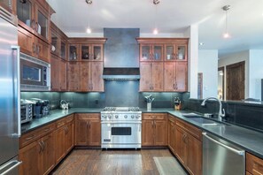 A modern kitchen with wooden cabinets, stainless steel appliances, and a central island.
