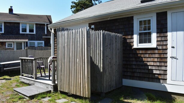 A residential property with a wooden deck, a small porch, and a shed.