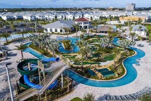 A resort with a large pool area, water slides, and a variety of outdoor seating areas. - 4BR Home w/Pool & Waterpark - Storey Lake (3053GS) (Kissimmee)