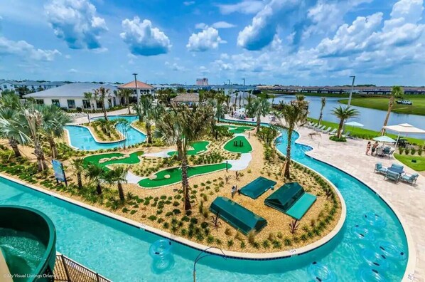Un resort con amplias zonas de piscina, palmeras y un campo de golf.