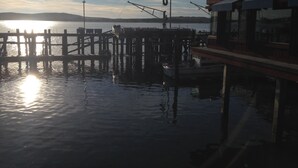 A pier extending into calm water with a boat docked at the end.