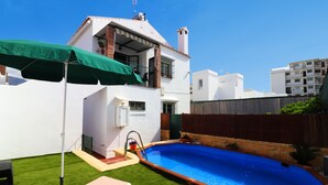 A residential property with a swimming pool, a covered patio, and a well-maintained lawn. - 1028 Casa Evelyn D (Nerja)