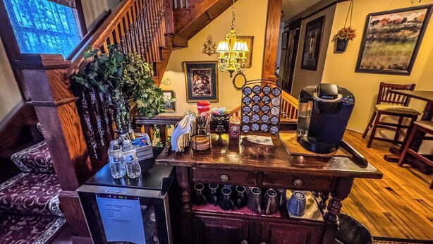 A cozy interior with a wooden staircase, a coffee station, and a dining area. - The Katherine Holle House (Watertown)