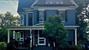 A two-story house with a porch, a front door, and a small front yard. - The Katherine Holle House (Watertown)