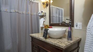 Une salle de bain avec un lavabo blanc, un miroir et un rideau de douche.