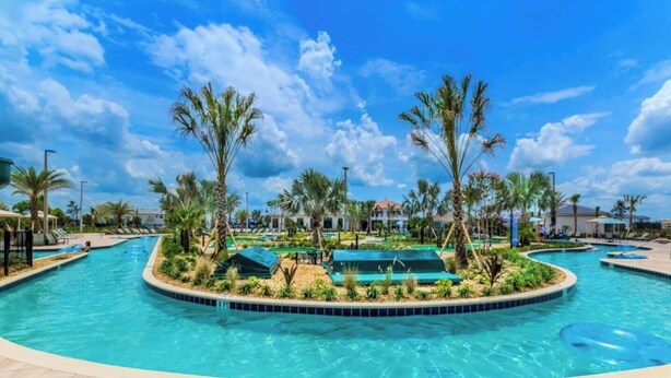 A large outdoor swimming pool with multiple lanes, surrounded by palm trees and lounge chairs. - Modern 7BR w/Pool/ Minutes from Disney/ ESPN (Kissimmee)
