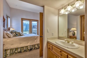 Enjoy a restful stay in this stylish bedroom with a large bed, nightstand, and dresser, featuring a mountain view.