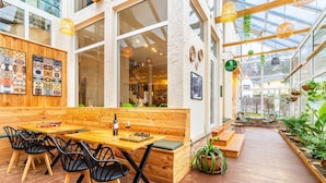 Un café acogedor con muebles de madera, un tablero de ajedrez y una planta verde.