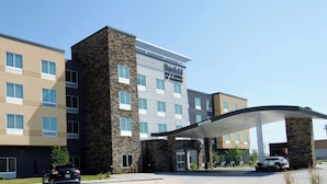 A hotel with a modern design, featuring a stone facade and a covered entrance.