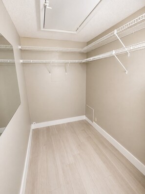 A room with a sloped ceiling, wooden flooring, and white walls.