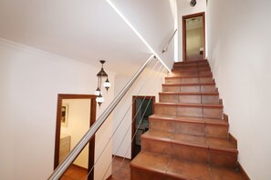 A staircase with wooden steps and a metal handrail, leading to an upper floor. - 1093 Villa Magnolias (Torrox)