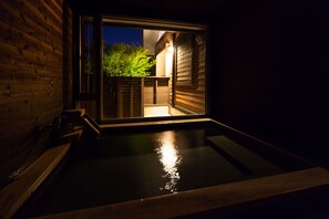 A wooden exterior wall with a glass door leading to a heated outdoor area. - Yufuin Jiyukan (Yufu)