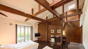 Habitación de hotel con dos camas, un escritorio, una silla y un televisor.