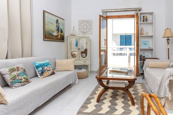 A living room with a sofa, a coffee table, a cabinet, and a bookshelf.