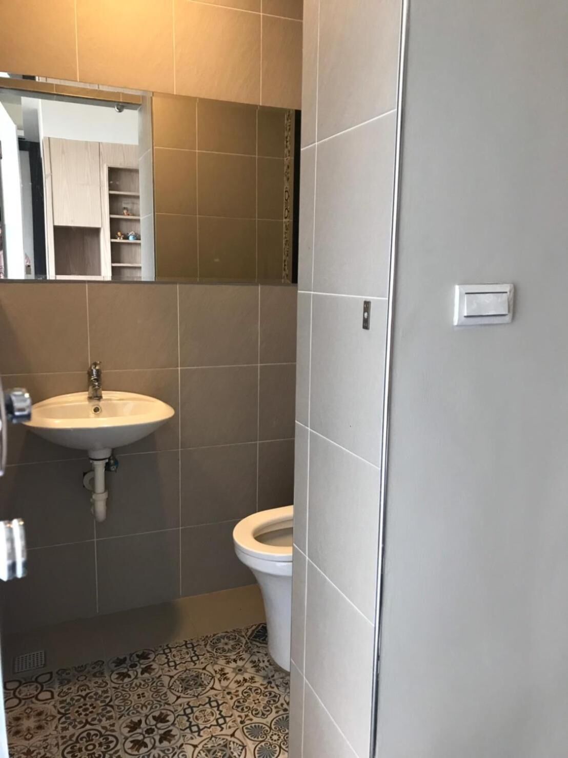 Une salle de bain avec un lavabo, des toilettes et un miroir.