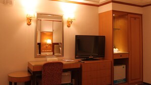 A hotel room with a desk, chair, television, mirror, and wardrobe. - Beverly Commercial Motel (Taoyuan City)