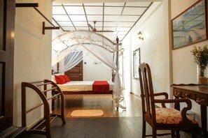 A bedroom with a bed, a chair, a desk, and a window with a view. - Dutch Wall (Galle)