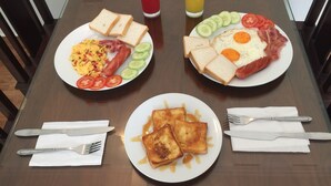 Ein Frühstückstisch mit Eiern, Toast und einem Smoothie.