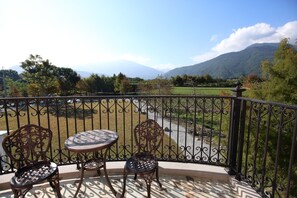 A balcony with wrought iron railings, two chairs, and a small table. - Serrado Manor (Ji'an)